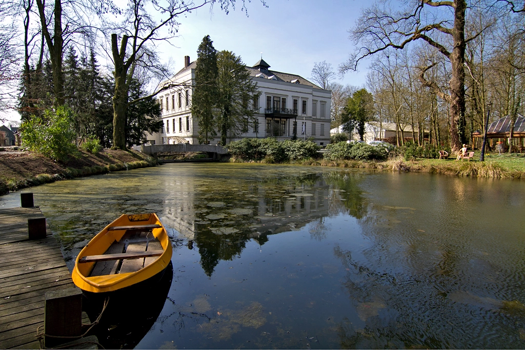 Castle De Berckt viewed across the pond with rowboat in the foreground